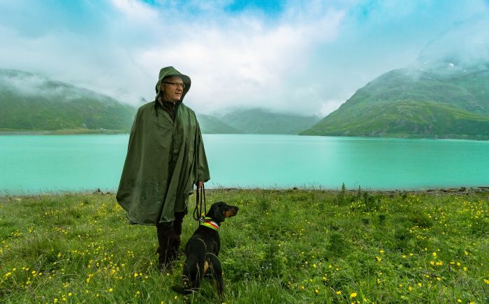 Un uomo con un cane sulla riva del lago.